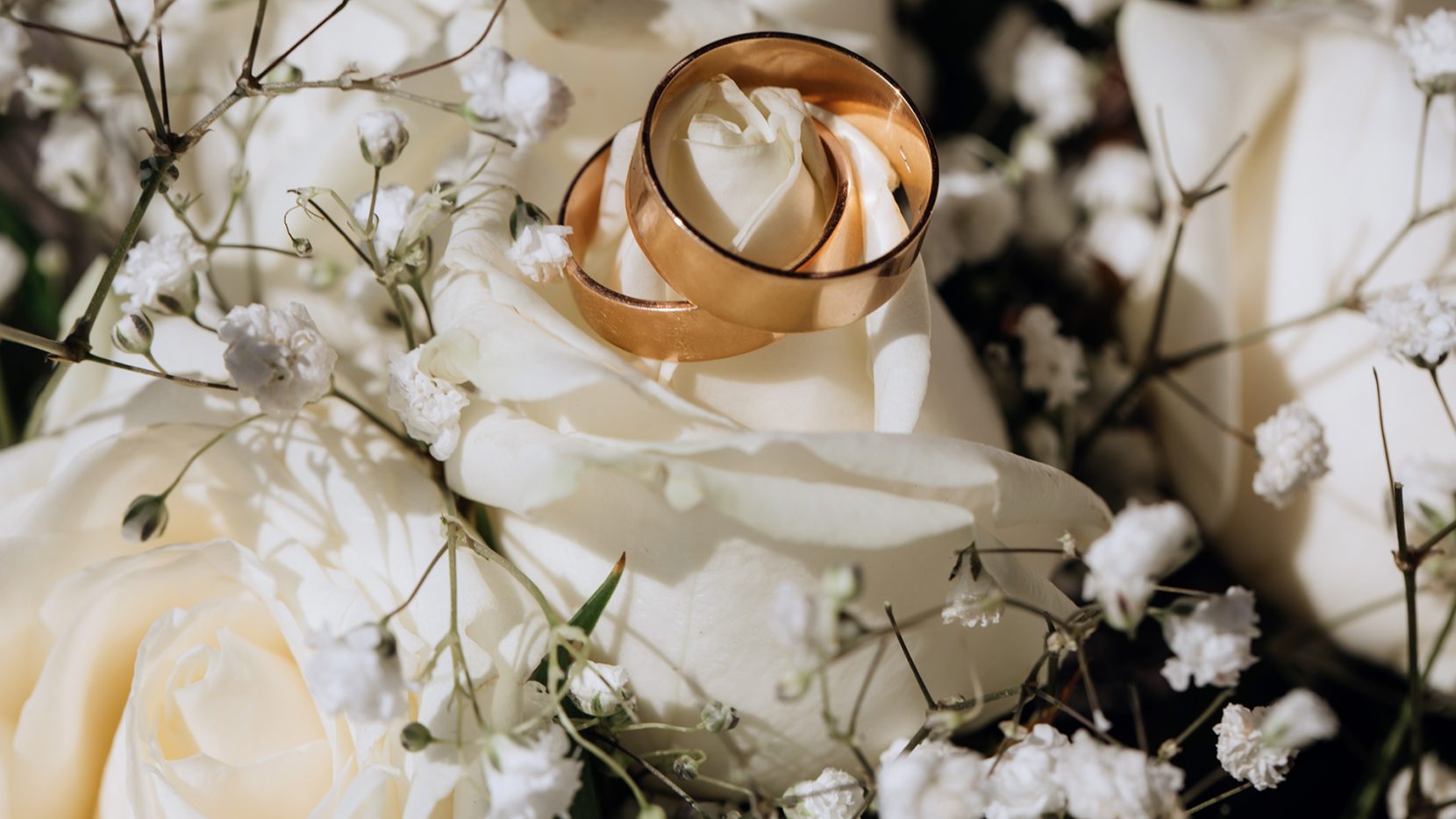 Two wedding rings on a white bouquet