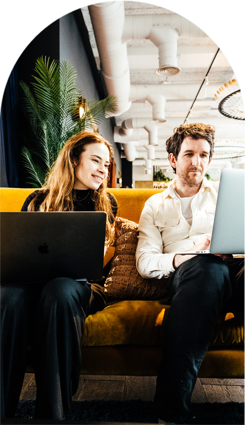 Coworkers at Kindred, Bradmore House, working from a sofa in The Hall